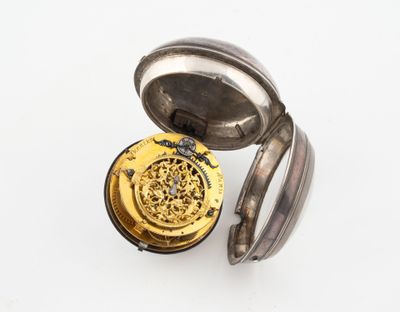 une vieille montre de poche posée sur une surface blanche
