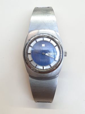 une montre en argent avec un cadran bleu sur un fond blanc