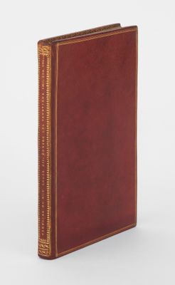 un livre marron avec une bordure dorée et une couverture rouge