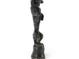 statue d'une femme debout sur un piédestal, les mains sur les hanches