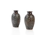 two brown vases sitting next to each other on a white surface