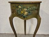 an old table with a painted flower on the top of it