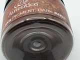 a close up of a jar of chocolate colored paint on a white surface