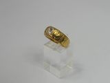 a close up of a gold ring on a clear stand