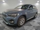 the bmw x1 is parked in a garage with a checkered floor