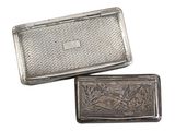 two antique silver cigarette cases with engraved designs on them on a white background