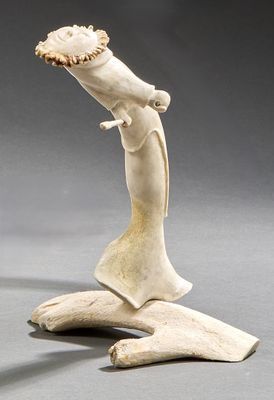 sculpture of a man with a hat on his head on a rock
