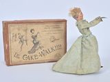 une poupée en robe verte à côté d'une boîte de « cakewalks »