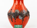 a red vase with black and white flowers on it