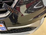 a man standing in front of a car with a guitar on it