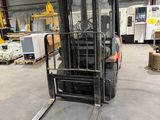un chariot élévateur dans un entrepôt rempli de cartons