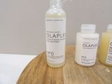 a bottle of olaple and two bottles of lotion on a table
