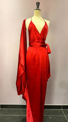 La robe rouge est exposée sur un présentoir à mannequin.