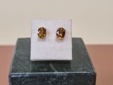 a close up of a pair of earrings sitting on top of a marble block