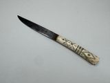 a close up of a knife on a table with a white background