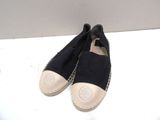 pair of black and white espadrills sitting on a white surface
