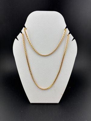 a gold chain necklace on a mannequin display