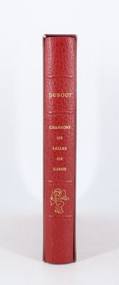 un vieux livre rouge posé sur une table à côté d'un mur blanc