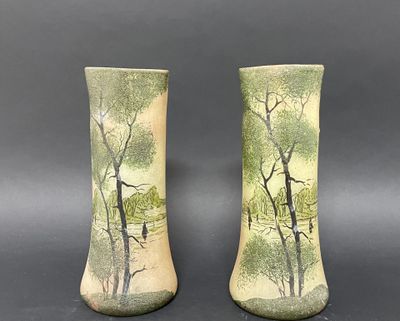 une paire de vases verts ornés d'arbres, posés sur une table