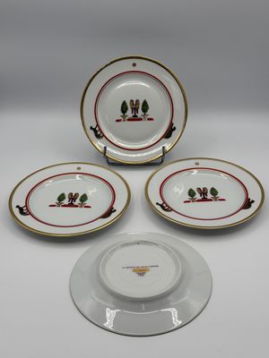 three plates and a bowl with a bird on them