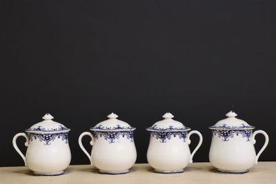 four blue and white teapots lined up on a table