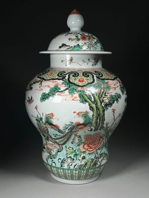un vase muni d'un couvercle orné d'un oiseau et de fleurs