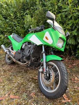 une moto verte garée dans l'herbe
