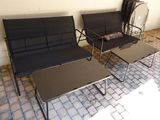 two black chairs and a table on a brick patio