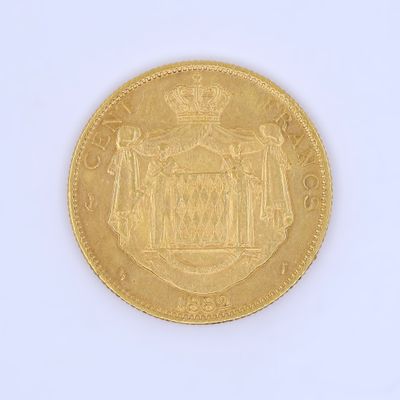 a gold coin on a white surface with a crown on it