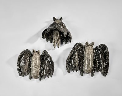 trois pièces de métal noir et argenté sur une surface blanche