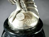 a silver statue of a shoe on a black base