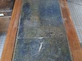 a table with a slate top on a tile floor