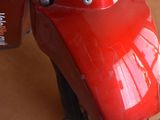 a close up of a red motorcycle on a wooden floor