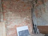 a room with a brick wall and a chair in it