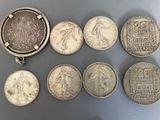 six different types of silver coins on a gray surface