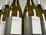 six bottles of white wine are lined up on a table