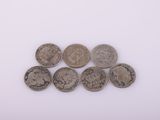 six pièces de monnaie britanniques différentes empilées les unes sur les autres sur une surface blanche