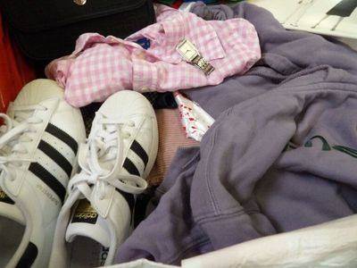 a pile of clothes and shoes in a suitcase
