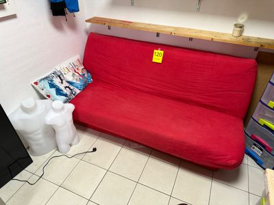 a red futon couch in the corner of a room