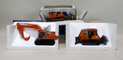 deux boîtes contenant chacune une petite pelleteuse et une boîte contenant un petit bulldozer