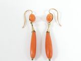 an image of a pair of orange earrings on a white surface