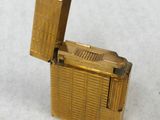 a gold lighter that is sitting on a white surface