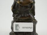 an image of a statue of a man sitting on a rock
