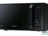 Le micro-ondes Samsung est noir et dispose d'une horloge numérique sur la façade.