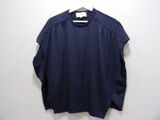a blue shirt hanging on a hanger against a wall