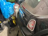une voiture garée dans un garage à côté d'une pile de bagages