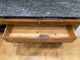 a black marble top on a wooden drawer
