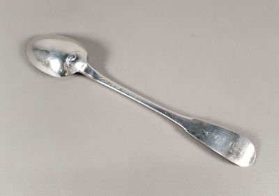 une cuillère en argent avec un manche de cuillère sur une table