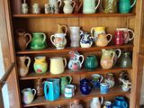 Il y a de nombreux types de tasses sur les étagères de cette armoire.