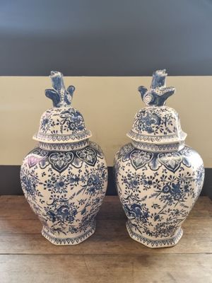 pair of blue and white vases with birds on them on a wooden table